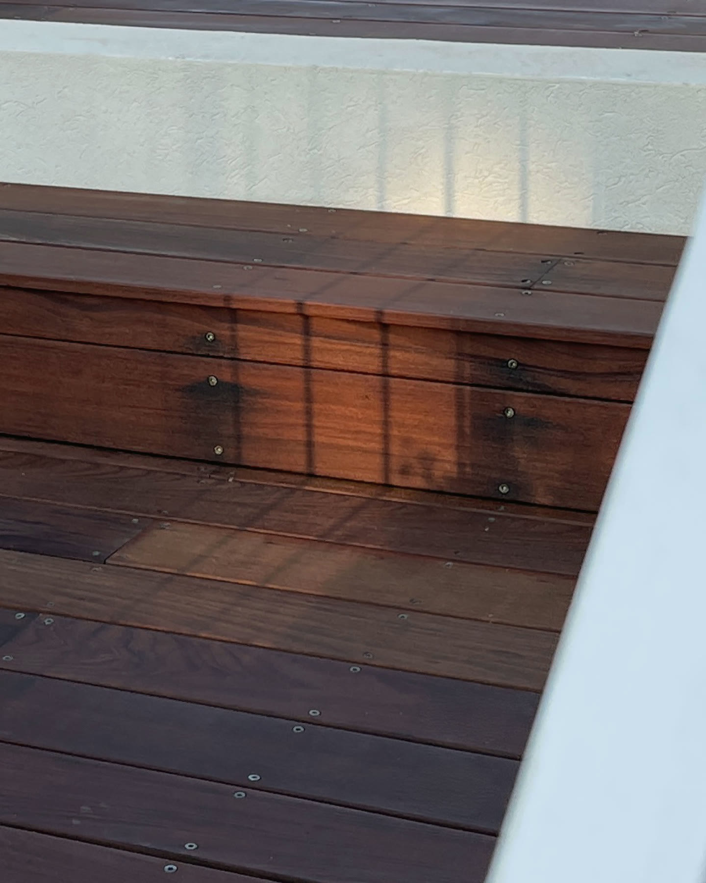 The restored wood — deep, oiled ipe in evening shadow