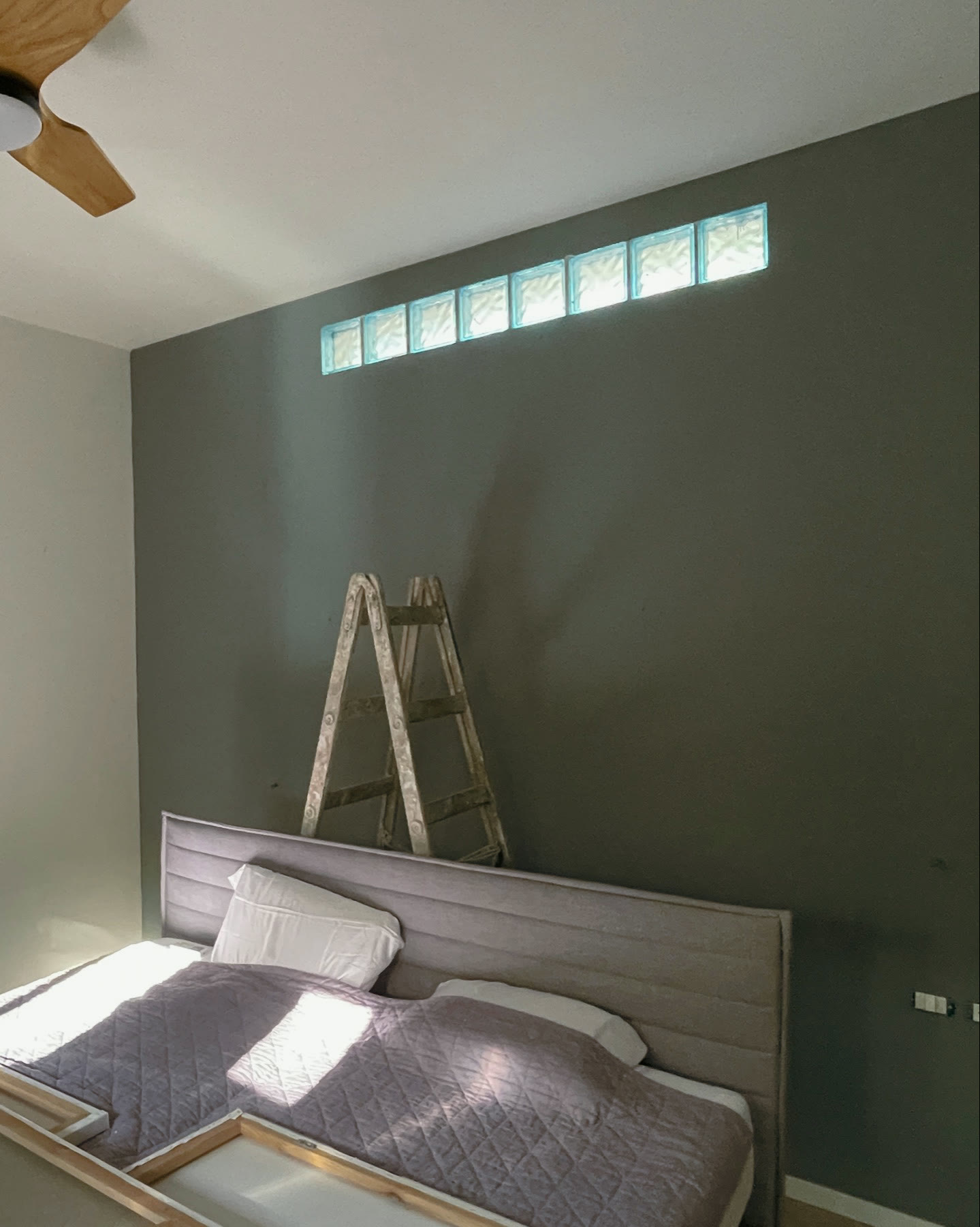 The same wall painted a deep quiet green, the room settling back to itself